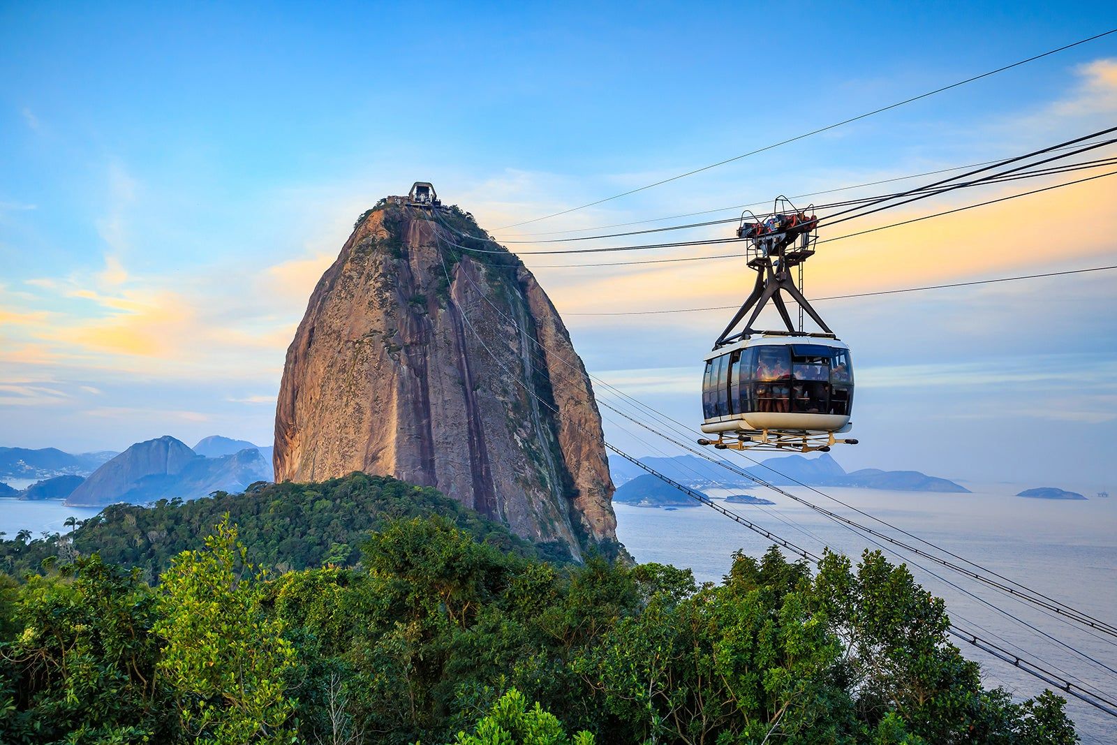 Bondinho do Pão de Açúcar sobrevoando a Baía de Guanabara ao entardecer
